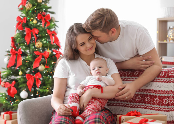 Happy couple with baby celebrating Christmas together at home - Foto, Imagem