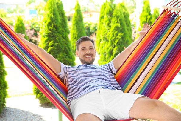 Man relaxing in hammock outdoors on warm summer day - Foto, Imagen