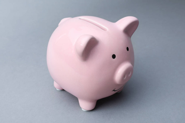Cute pink piggy bank on gray background - Foto, immagini