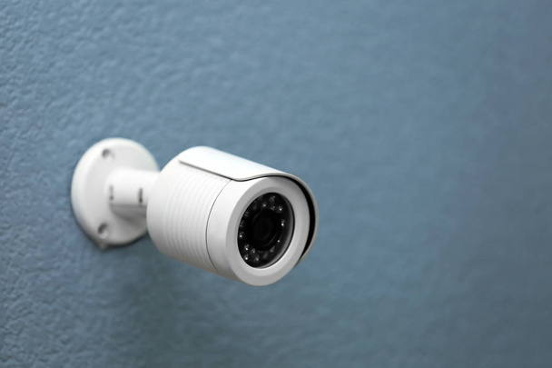 Modern security CCTV camera on grey wall - Foto, afbeelding