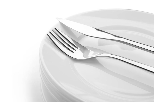 Stack of plates with fork and knife, closeup - Valokuva, kuva