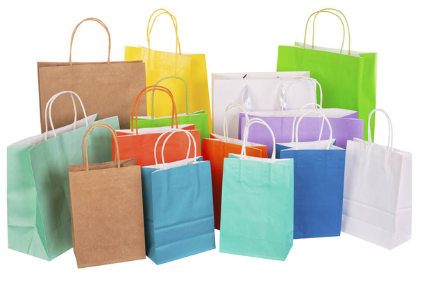 Variety of colored paper shopping bags on white background. Empty area. - Фото, изображение