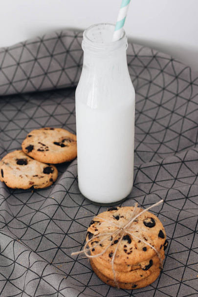 νόστιμα σπιτικά τραγανά μπισκότα σοκολάτας και ένα μπουκάλι γάλα  - Φωτογραφία, εικόνα