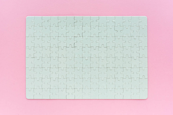 Complete blank jigsaw puzzle as mock up copy space, top view of surface on pink background - Fotoğraf, Görsel