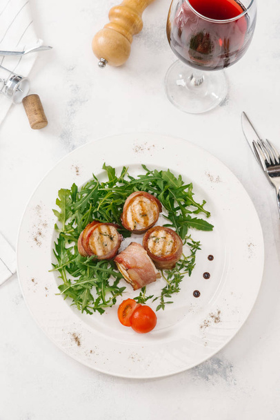 新鮮なベーコン ロールが白い皿にルッコラのサラダを添え - 写真・画像