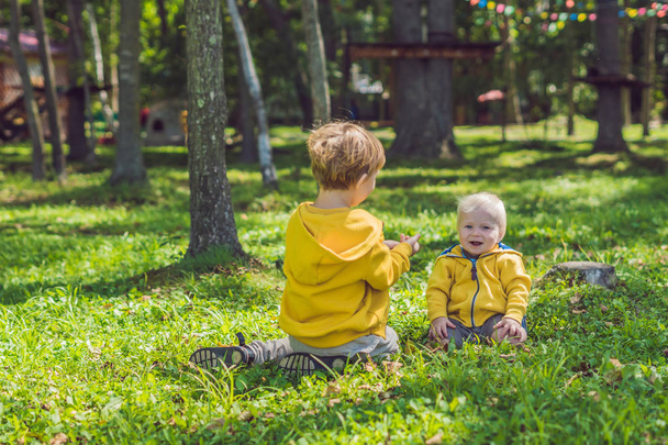 Δύο αδέλφια ευτυχισμένη σε κίτρινο πουκάμισα στο πάρκο φθινόπωρο - Φωτογραφία, εικόνα
