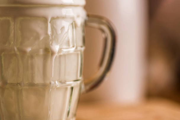 Primer plano vista fresca bebida probiotik kéfir emergió de vaso vacío sobrecargado en la mesa de la cocina
 - Foto, imagen
