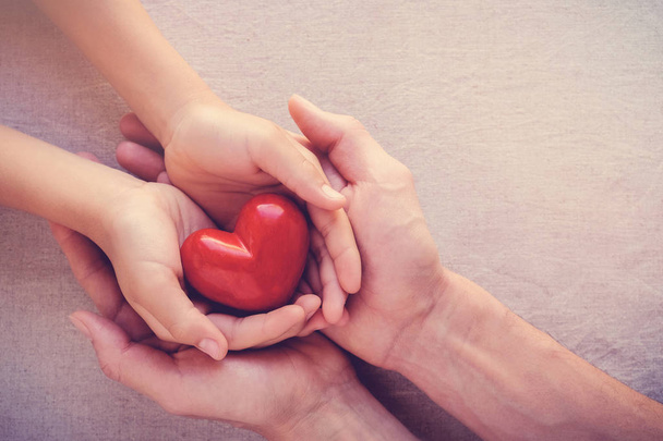 adult and child hands holiding red heart, health care love, give, hope and family concept - Photo, Image