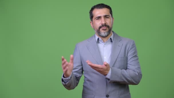 schöner persischer bärtiger Geschäftsmann zeigt etwas - Filmmaterial, Video