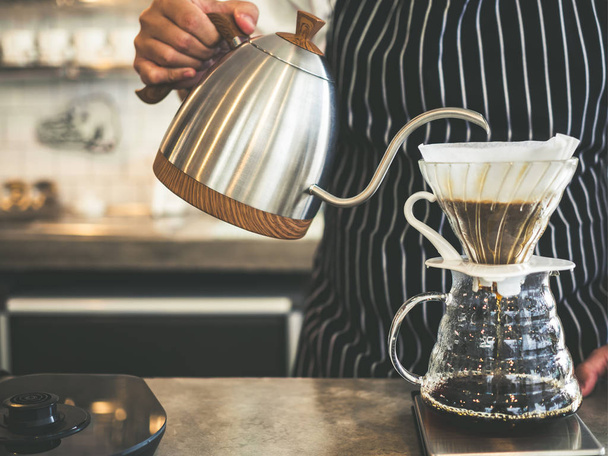 Parzenia kawy kroplówki, ręka lała ciepłej wody z czajnika proszku kawy Barista. - Zdjęcie, obraz