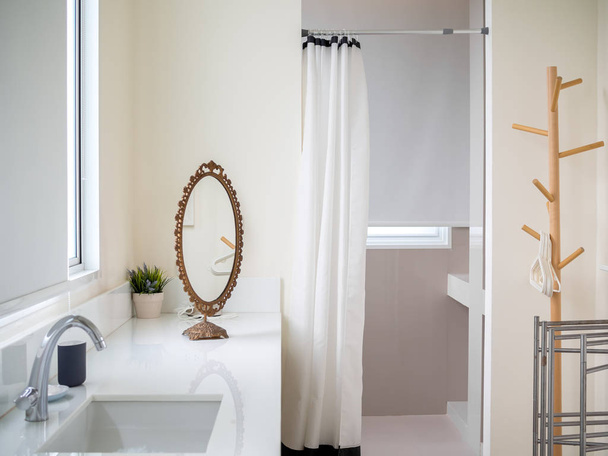 weiße Vintage Luxus Badezimmer mit Waschbecken, Spiegel, Pflanze im Topf, Vorhang und Kleiderbügel - Foto, Bild