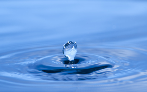 Photo abstraite de l'eau éclaboussure comme la couronne, fond bleu
 - Photo, image