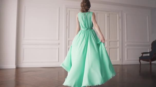 a young girl in a green dress. portrait of an attractive brunette with beautiful makeup and hair. girl spinning in a dress. slow motion - Footage, Video