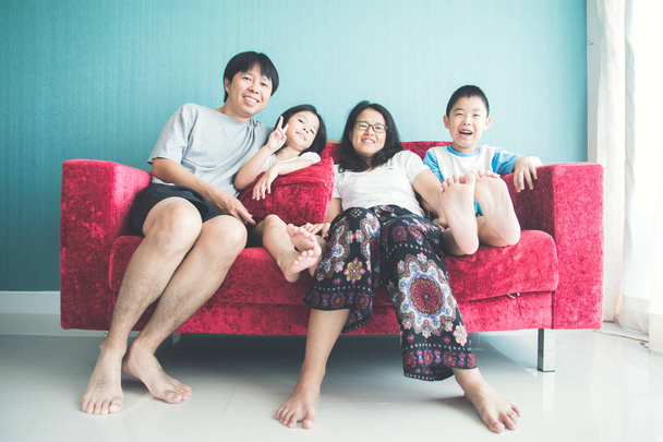 Ευτυχισμένη οικογένεια στον καναπέ στο δωμάτιο - Φωτογραφία, εικόνα