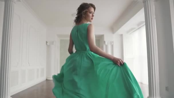 a fashionable girl in a fluttering dress runs away from the camera and looks around. the fabric flutters beautifully. slow motion - Footage, Video