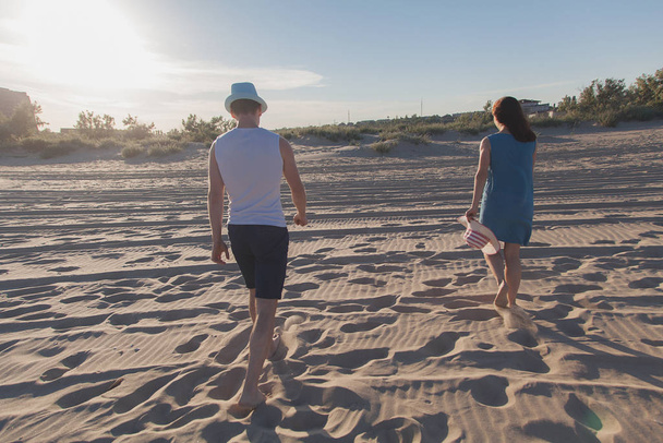 Muž a dívka se chůzi po písku. - Fotografie, Obrázek