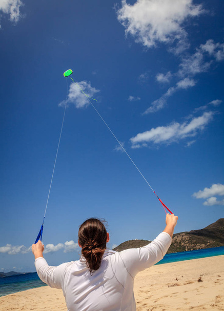 Vrouw vliegt kite op een tropisch strand in Caribisch gebied - Foto, afbeelding
