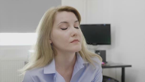 Depressed young corporate employee suffering from headache feeling upset and fatigue at the office massaging her temples relieving the stress - Záběry, video