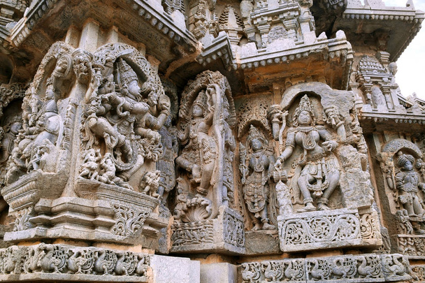 Painéis de parede ornamentados representando Shiva, Krishna como Kaliya-mardana e uma divindade e dança Parvati, templo Kedareshwara, Halebidu, Karnataka, Índia
 - Foto, Imagem