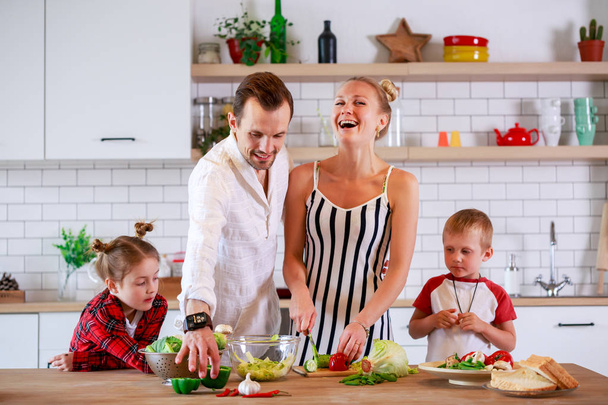 Kuva nuorista vanhemmista, joilla on poika ja tytär valmistamassa aamiaista
 - Valokuva, kuva