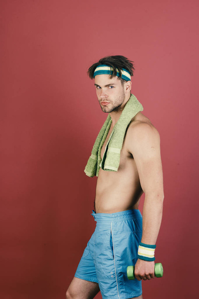 Sport and slim shape concept. Man with naked torso holds towel on neck and dumbbell - Foto, Imagem