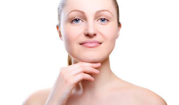 Portret van een meisje met naakt make-up met handen op kin geïsoleerd op een witte achtergrond. Meisje met een schone gezonde huid op wit. Cosmetologie, geneeskunde, schoonheidsverzorging. Naakt make-up - Foto, afbeelding