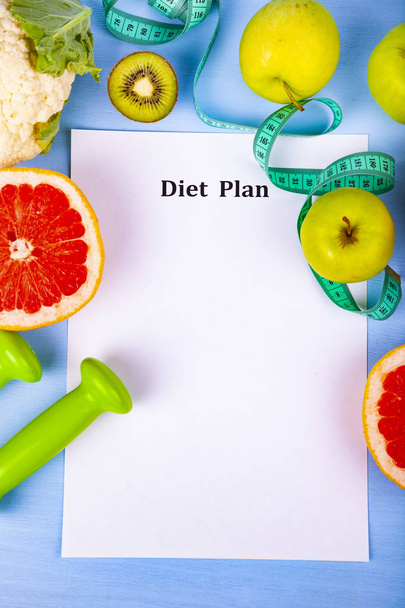 Food and sheet of paper with a diet plan on a blue wooden background. Concept of diet and healthy lifestyle. - Foto, Bild