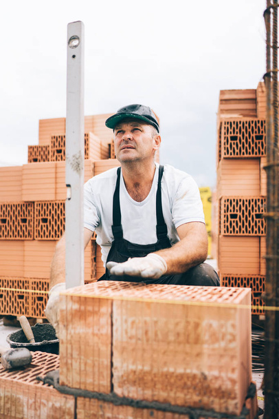 industrial worker, bricklayer or mason laying bricks and creating walls. Detail of level tool - Φωτογραφία, εικόνα
