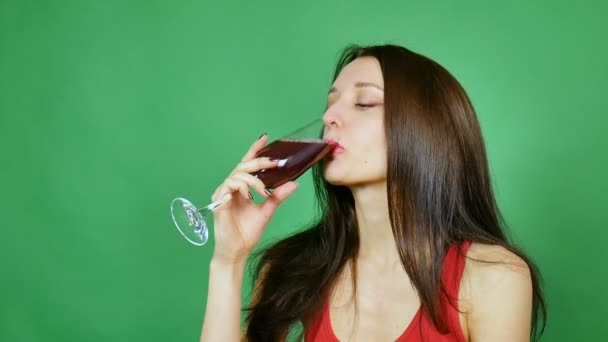 Bella ragazza sorridente e alzando un bicchiere di vino in brindisi. Indossava una maglia rossa. Sfondo verde
 - Filmati, video
