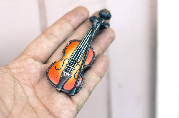Muzyczny pasja i hobby koncepcja, ręka trzyma skrzypce miniature.copy miejsca po prawej stronie tekstu - Zdjęcie, obraz