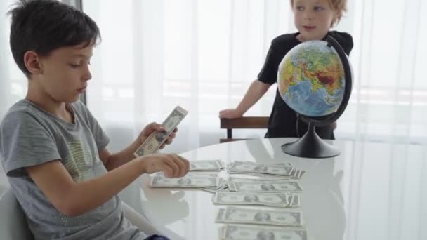 Two caucasian boys spin counting money for travel - Metraje, vídeo