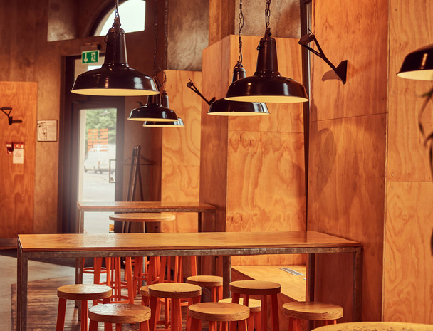 Interior del nuevo restaurante moderno o cafetería con pared de madera y muebles
. - Foto, Imagen