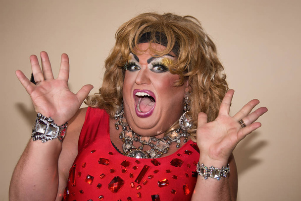 Funny travesty actor. Drag queen in red. Feelings and emotions. Fat man and make-up. Game - Photo, Image