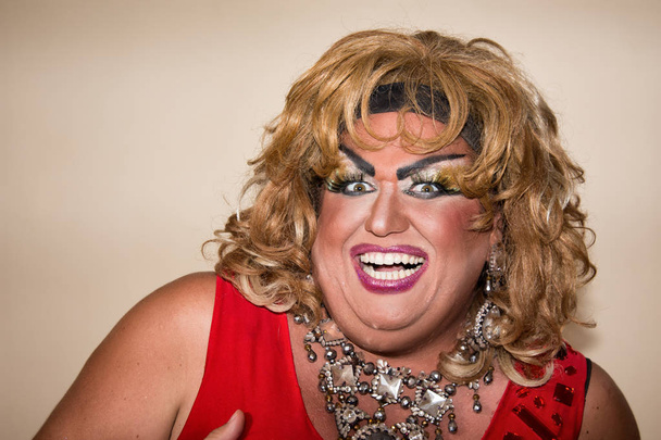 Funny travesty actor. Drag queen in red. Feelings and emotions. Fat man and make-up. Joy - Photo, Image