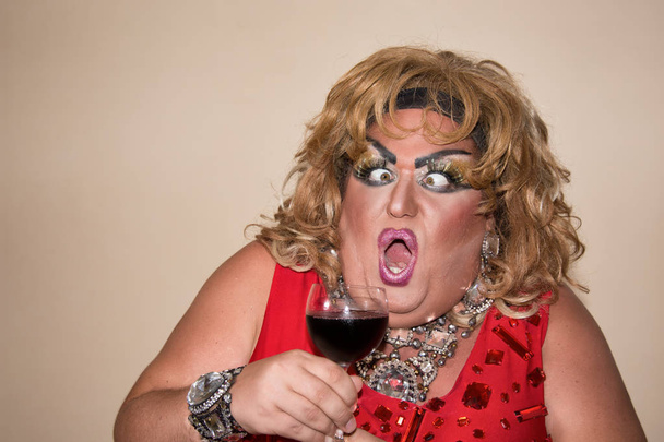 Zabawna parodia aktor. Drag queen i czerwone wino. Uczucia i emocje - Zdjęcie, obraz