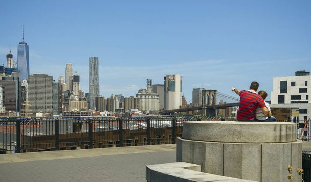Man showing to kid the Manhattan skyline in New York City - Фото, изображение