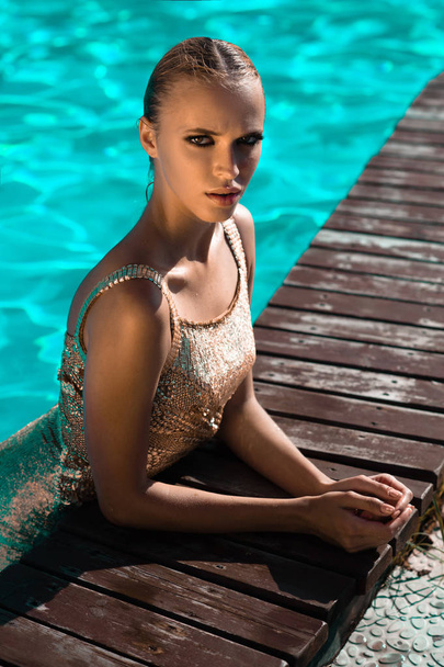 Beautiful girl swimming in the pool in Sunny weather - Zdjęcie, obraz
