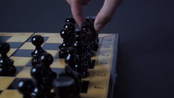 Panning shot of a chess board with a hand moving the chess pieces. - Filmagem, Vídeo