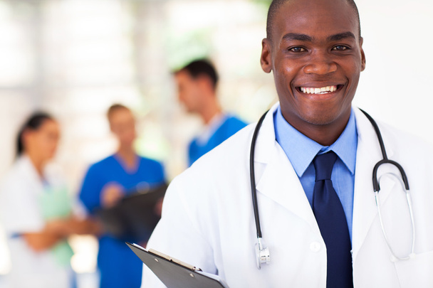 handsome african american medical doctor with colleagues in background - Photo, image