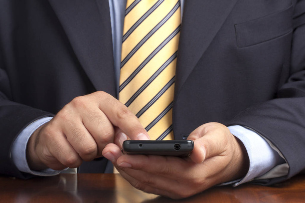 Closeup of businessman hands working on smartphone at desk - Foto, Imagem