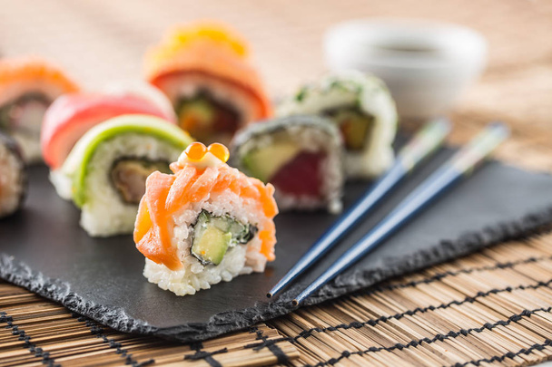 Set of roll sushi with chopsticks on slate board. - Photo, Image