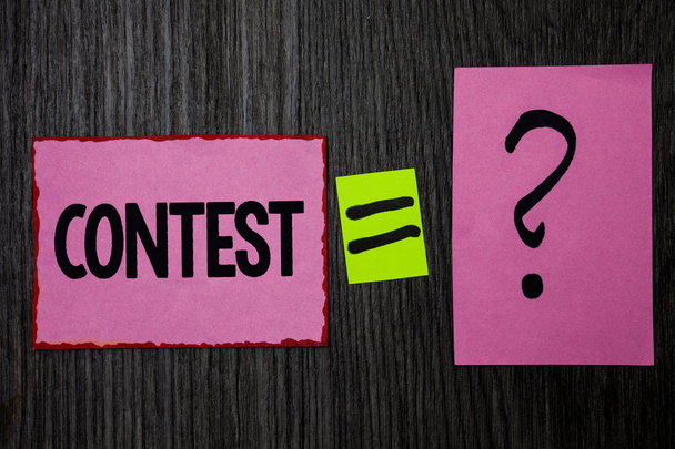 Writing note showing  Contest. Business photo showcasing Game Tournament Competition Event Trial Conquest Battle Struggle Pink notes equal sign question mark wooden wood background inspiration - Photo, Image
