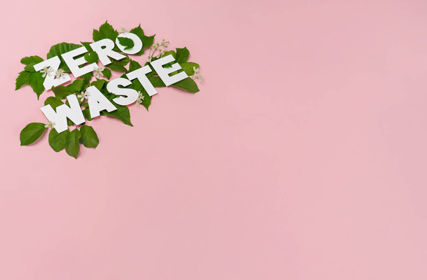 μηδέν απορρίμματα χαρτιού κείμενο εφαρμόζεται πράσινα φύλλα σε ροζ φόντο  - Φωτογραφία, εικόνα
