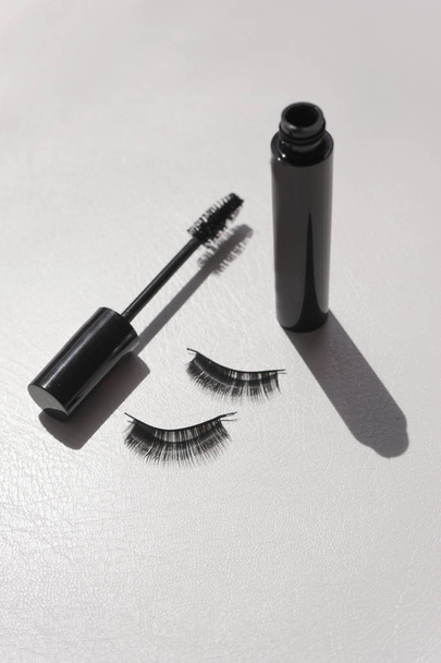 Black false lashes strips with mascara on white background  - Photo, Image