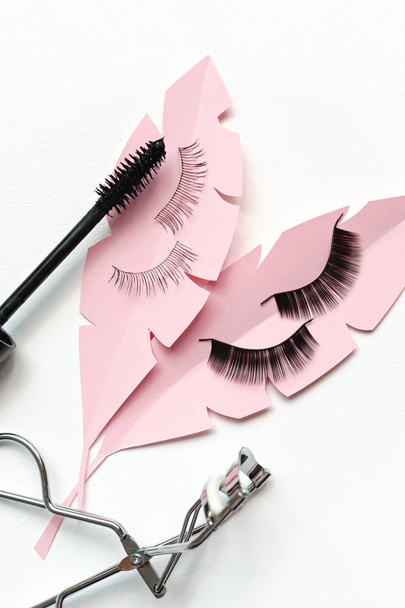 Black false lashes strips, mascara, curler  on white background  - Photo, Image