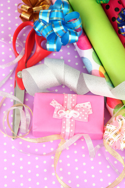 Rolls of Christmas wrapping paper with ribbons, bows on color background - Фото, зображення