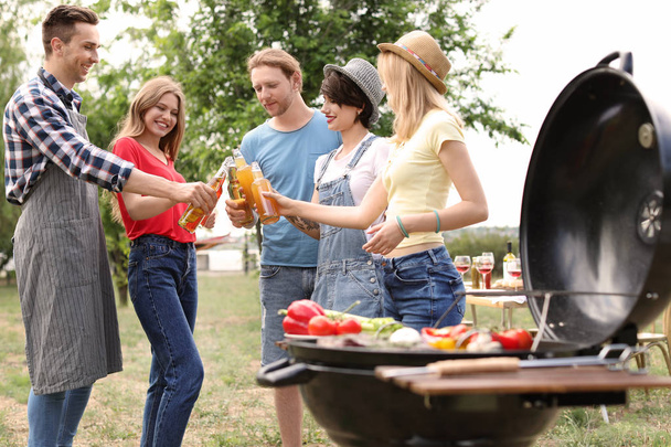 Young people having barbecue with modern grill outdoors - Fotografie, Obrázek