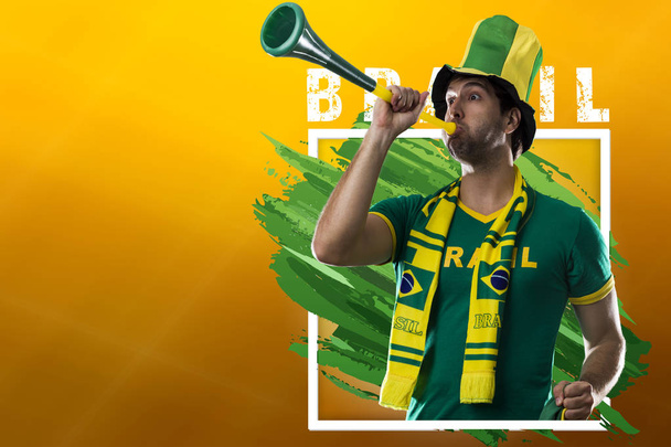 Brazilian male fan, celebrating on a yellow background with copy space. - Zdjęcie, obraz