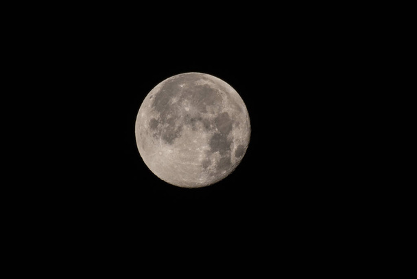 Truskawka Księżyc w pełni letniego przesilenia świeci jasny w niebo z usianymi lejami bocznymi tekstury powierzchni. - Zdjęcie, obraz