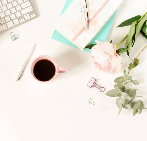 Flat lay women's office desk. Female workspace with laptop,  flowers peonies,  accessories, notebook, glasses, cup of coffee on white background. Top view feminine background.Copy space - Zdjęcie, obraz